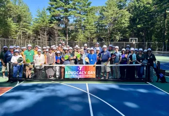 image of large group posing on pickleball courts