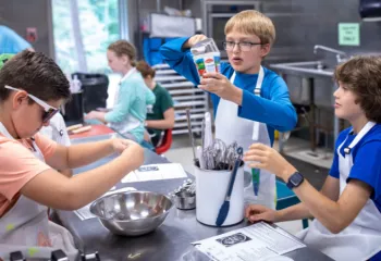 three boys mixing ingredients during cooking class