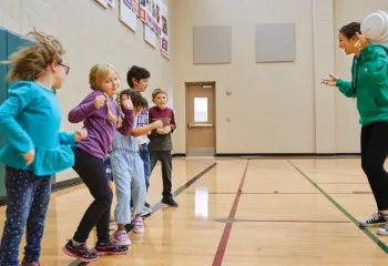 staff member and group of kids in gymnasium