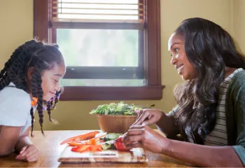 image of mom making a healthy salad with young daughter