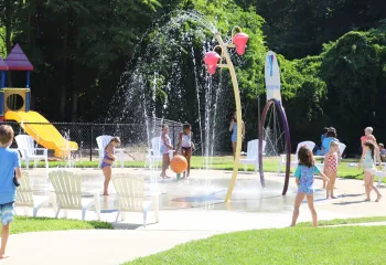 image of kids playing in a splash pad on a sunny day