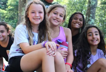 group photo of girls sitting outside and smiling