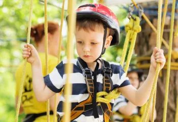 Little kid on MetroWest YMCA Hopkinton Outdoor Center Ropes Course