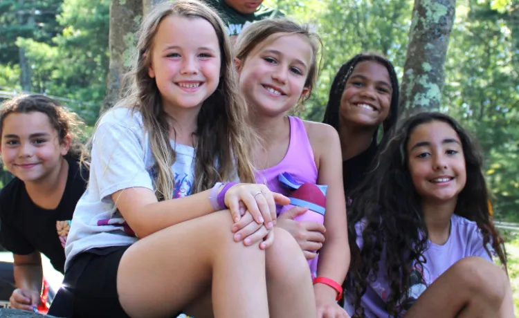 group photo of girls sitting outside and smiling