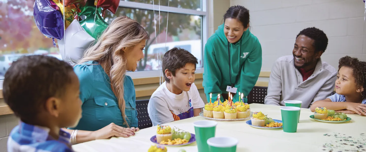 young boy blowing on birthday candles