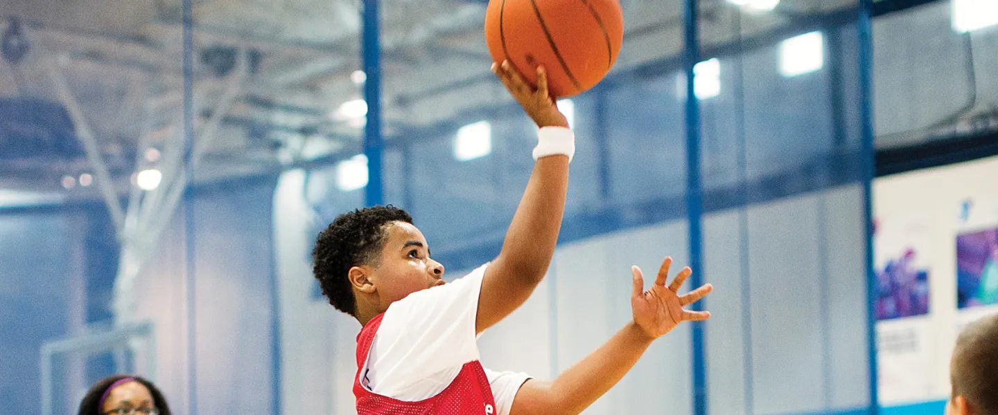 boy jumping to shoot a basketball