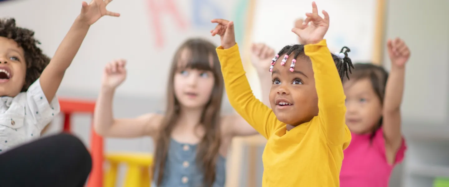 preschoolers with their arms in the air