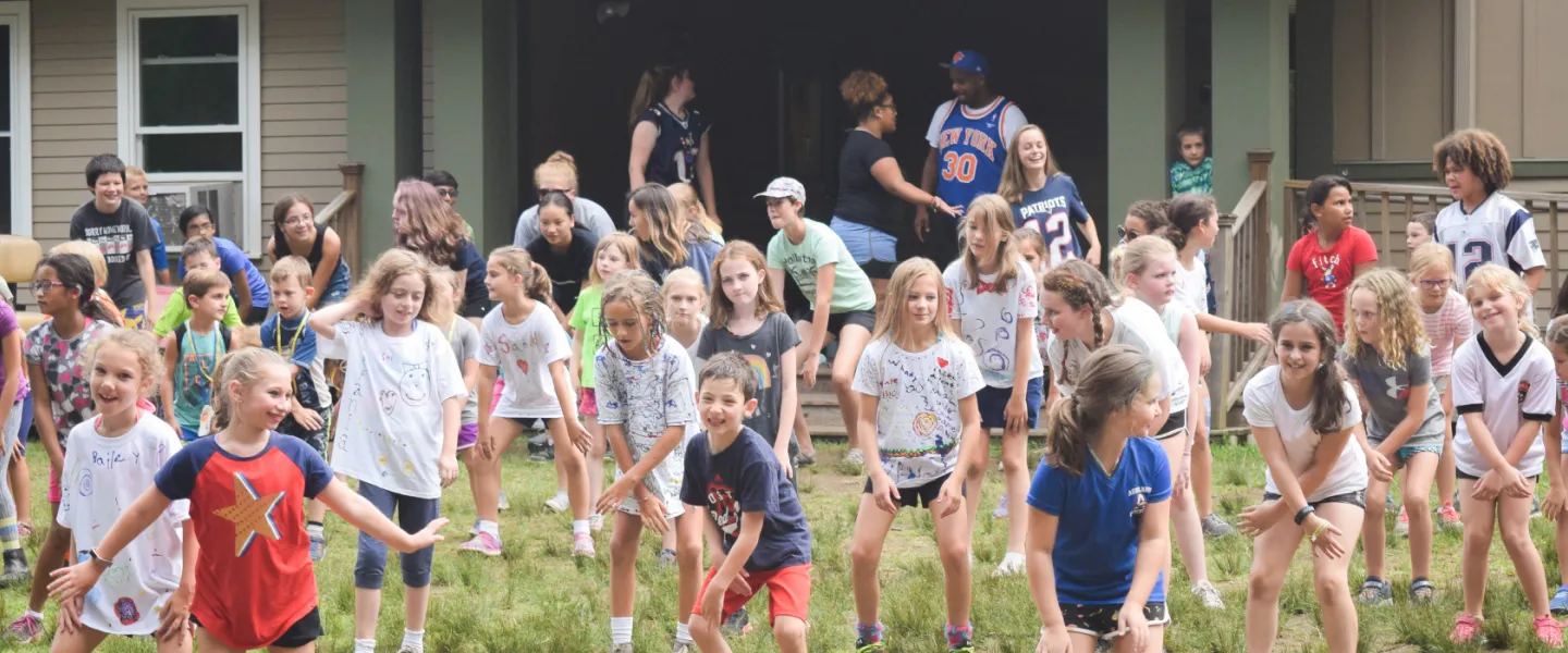 group of young campers dancing outside