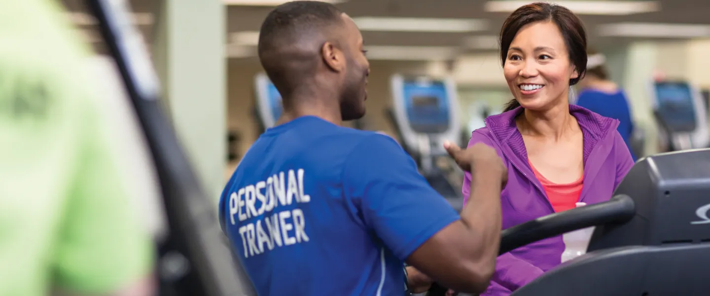 personal trainer working with client on the treadmill