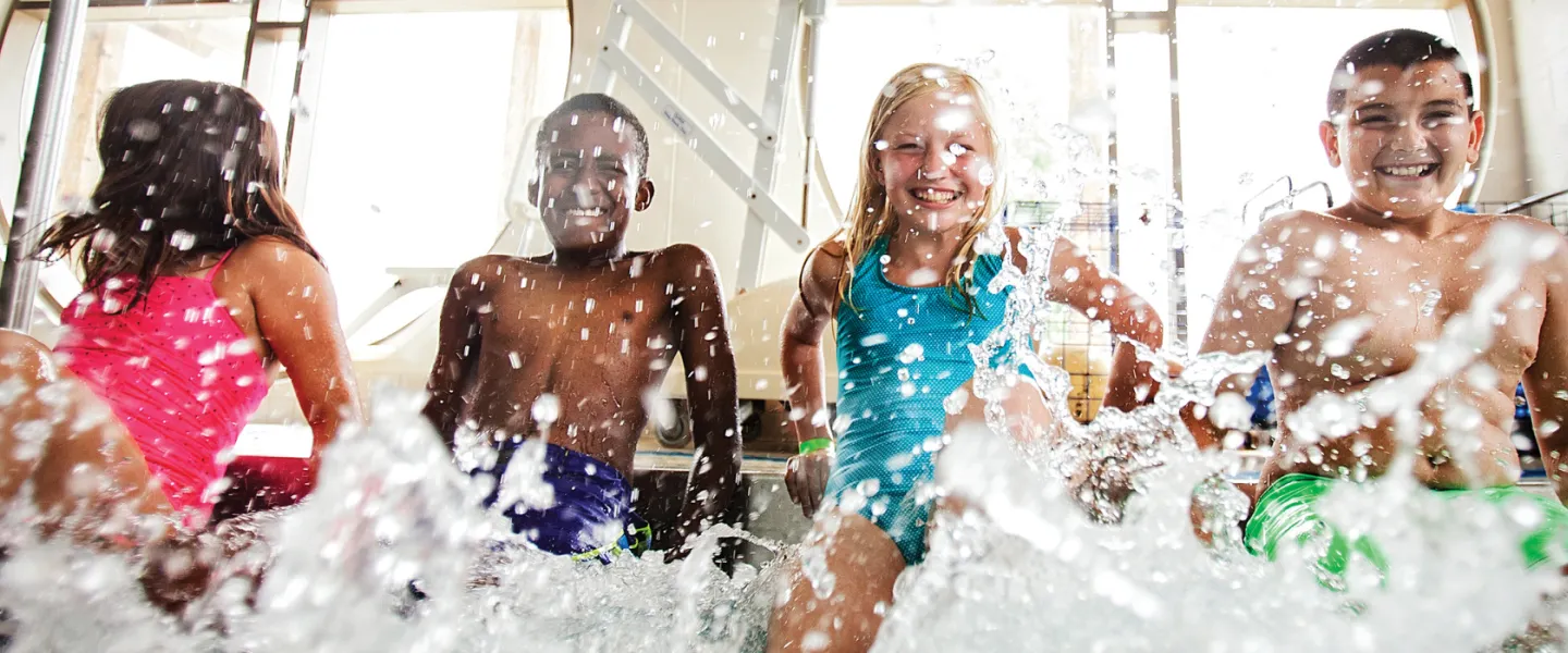 photo of four kids splashing their foot in the pool