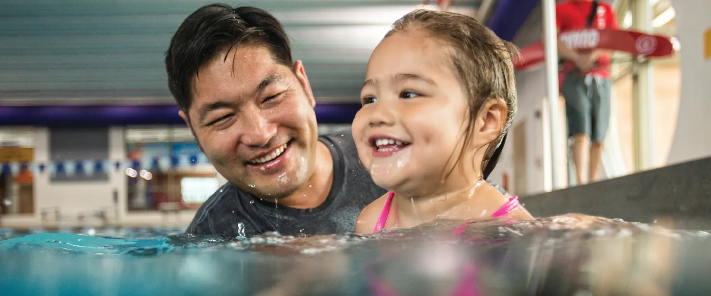 image of father helping young daughter swim