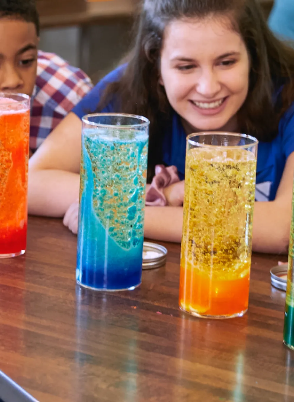 Teacher and students observe colorful science experiment