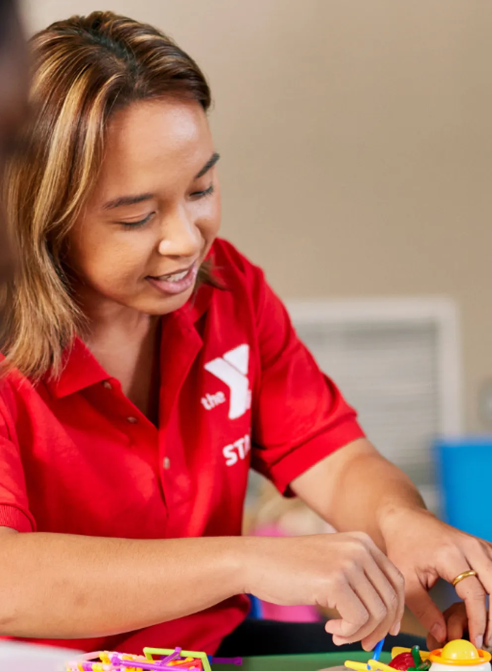 y staff member helping young child