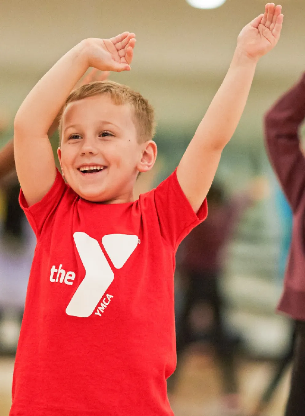 group of young kids smiling with their arms in the air