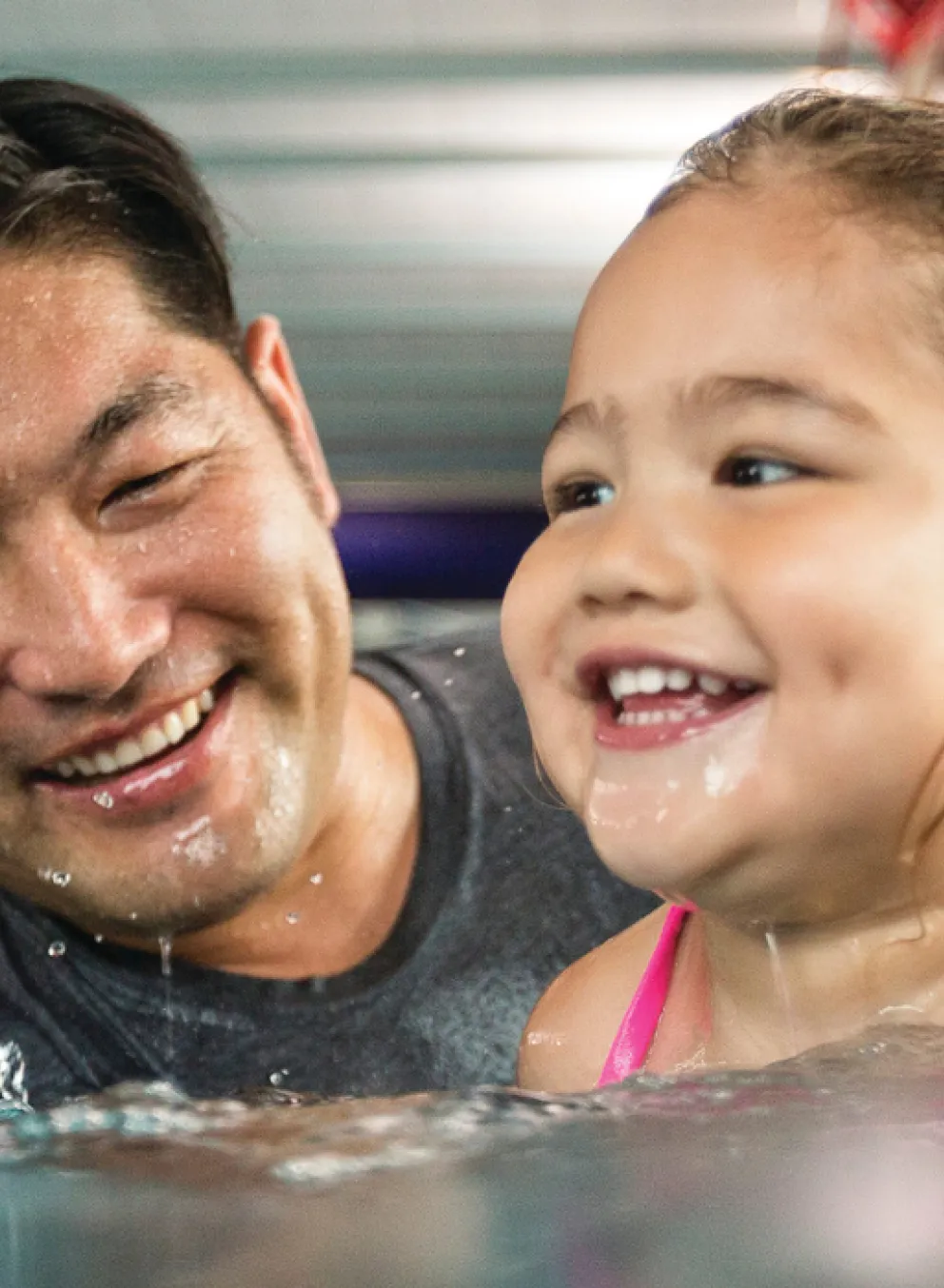 father teaching young daugther how to swim