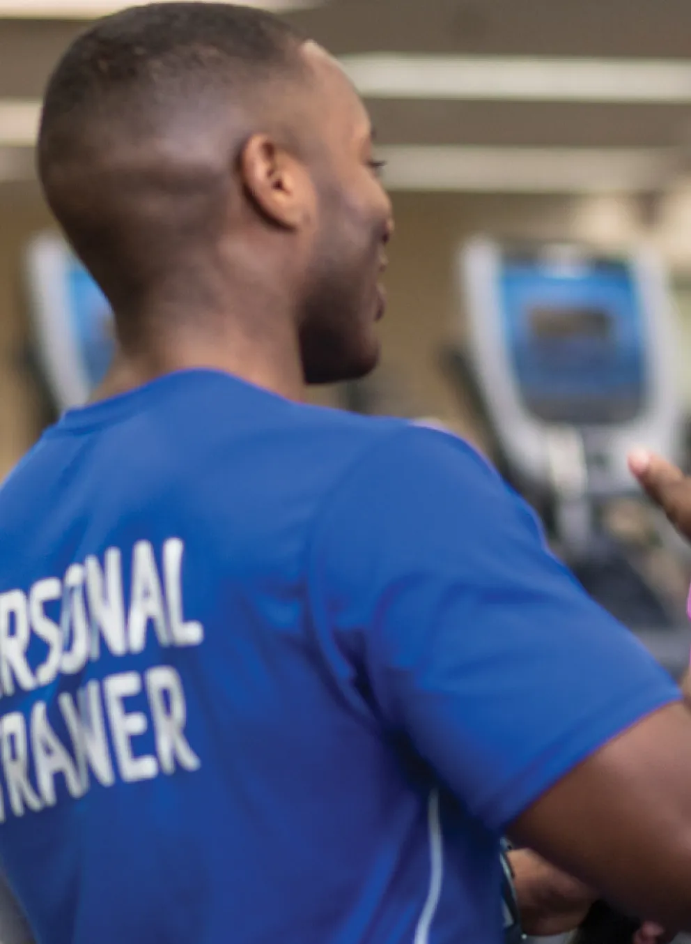 personal trainer working with client on the treadmill