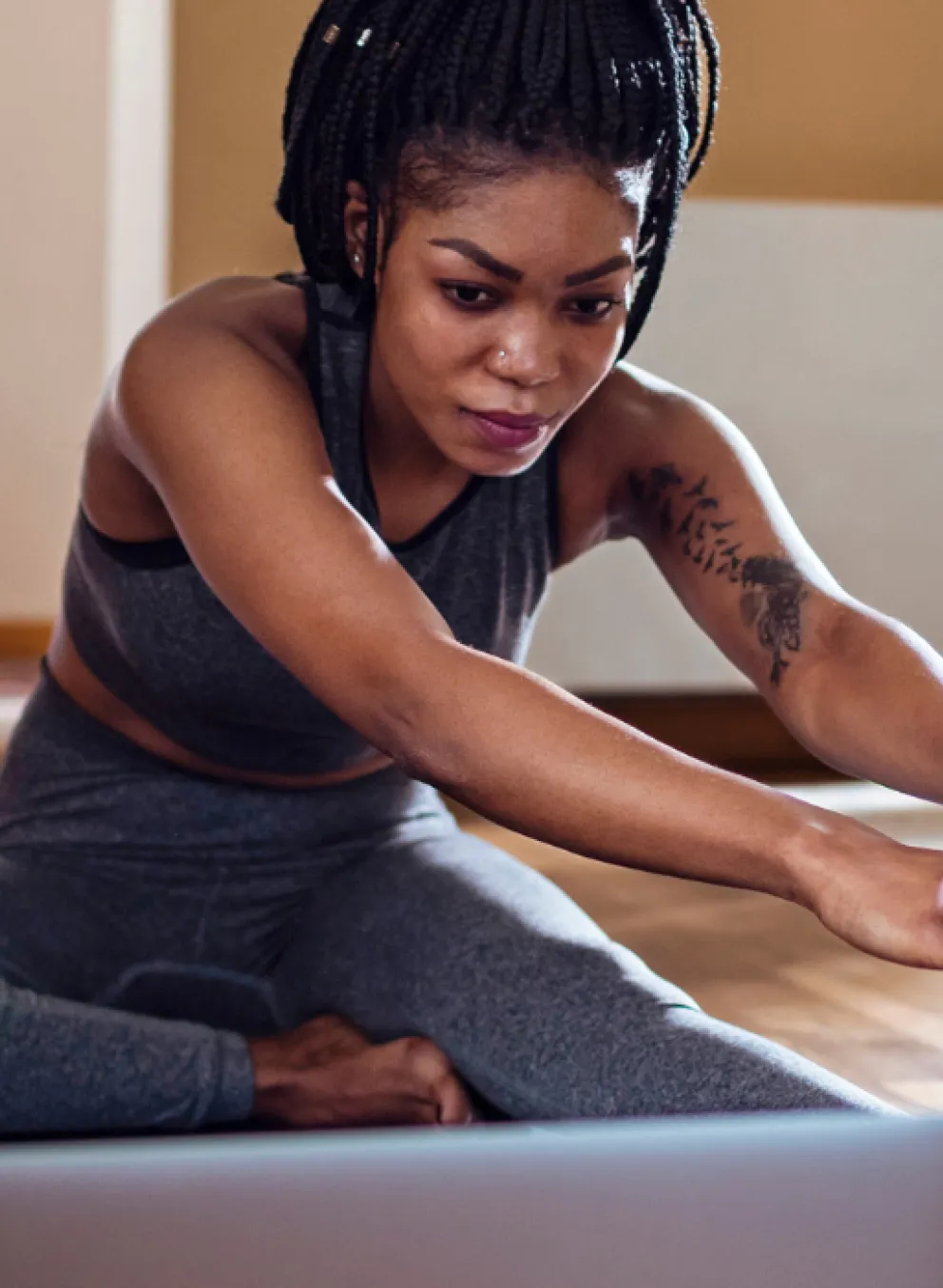 woman looking at laptop screen while stretching