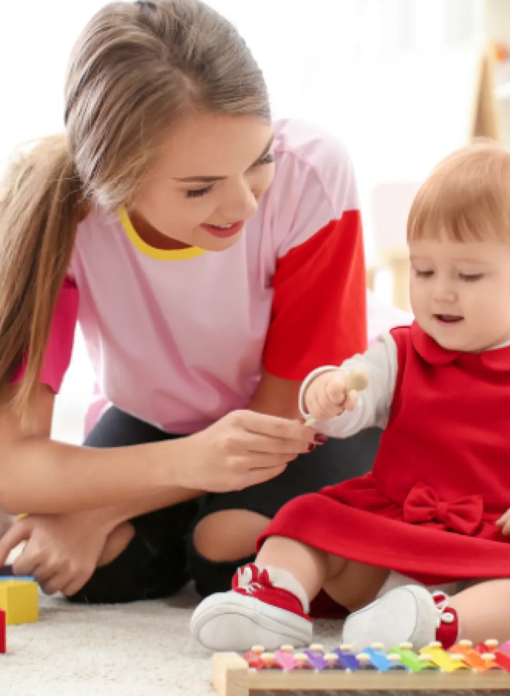 image of teenage girl babysitting young toddler
