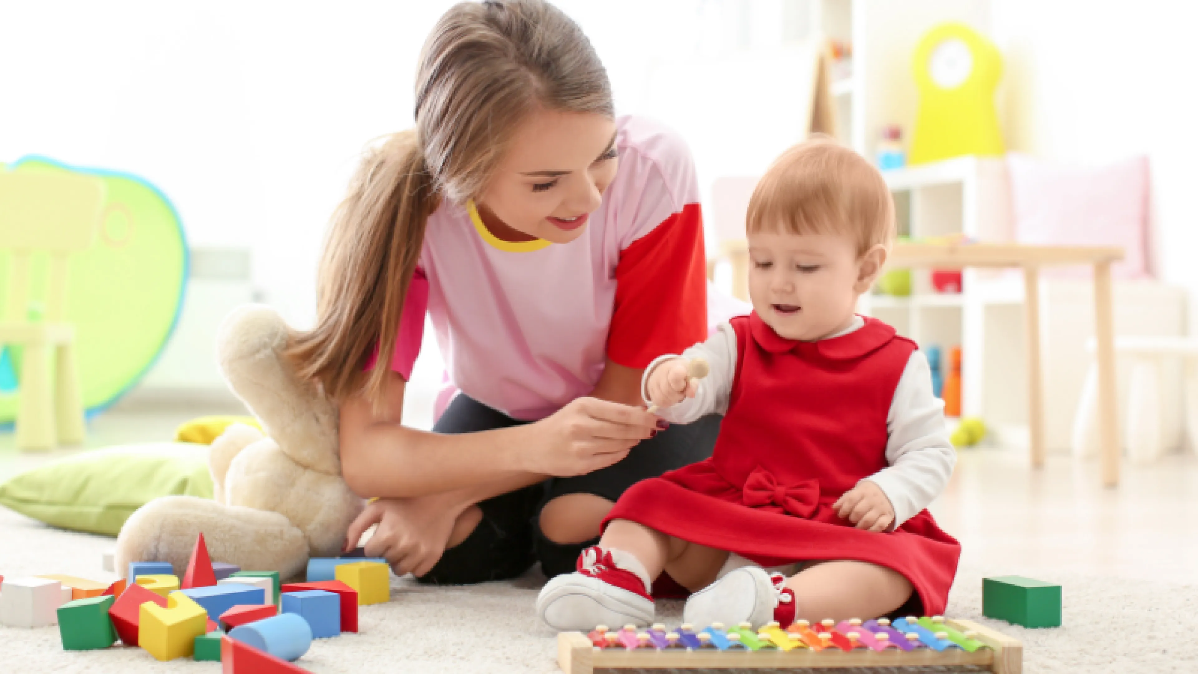 image of teenage girl babysitting young toddler