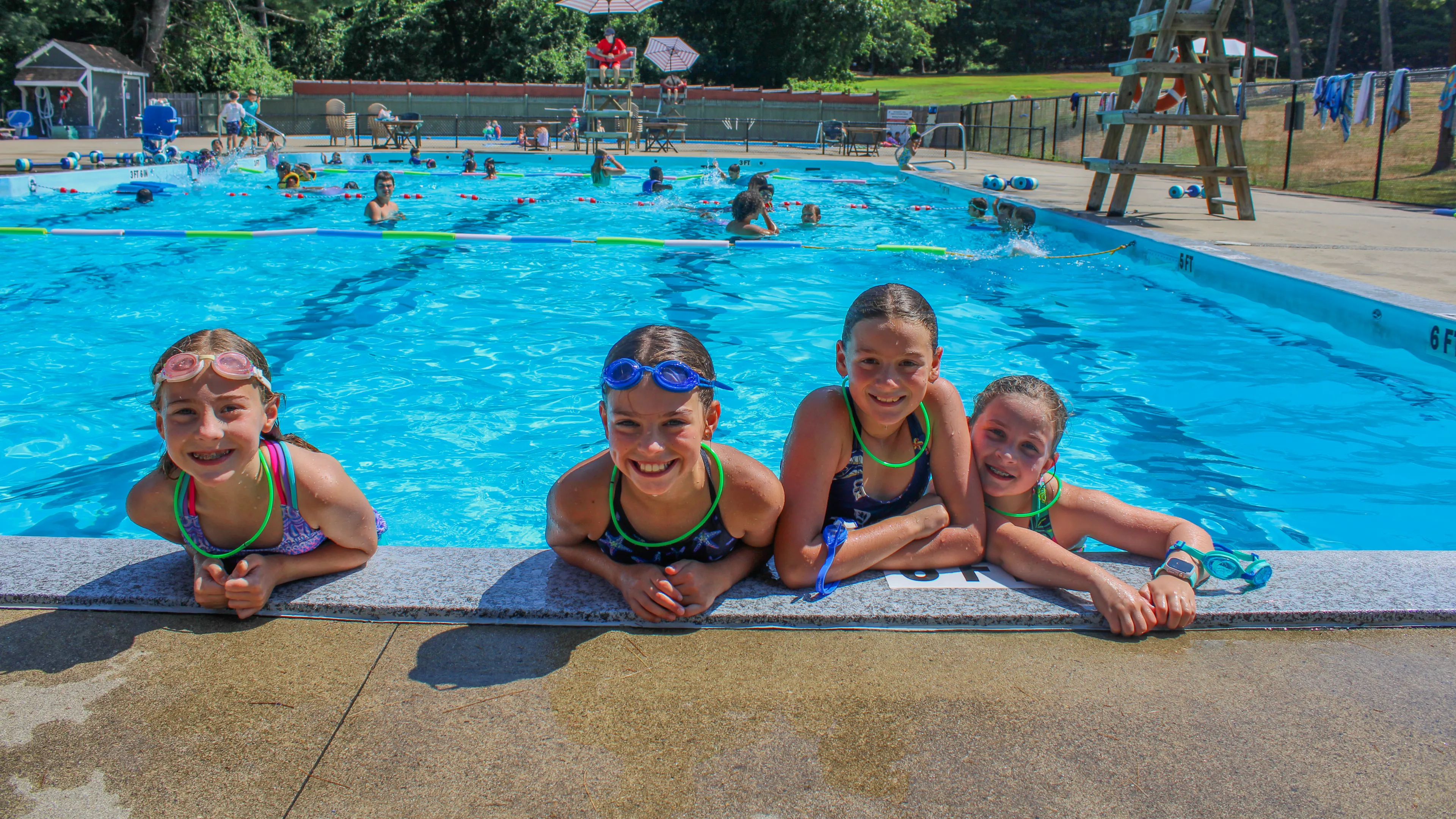 four girls at the edge of a pool