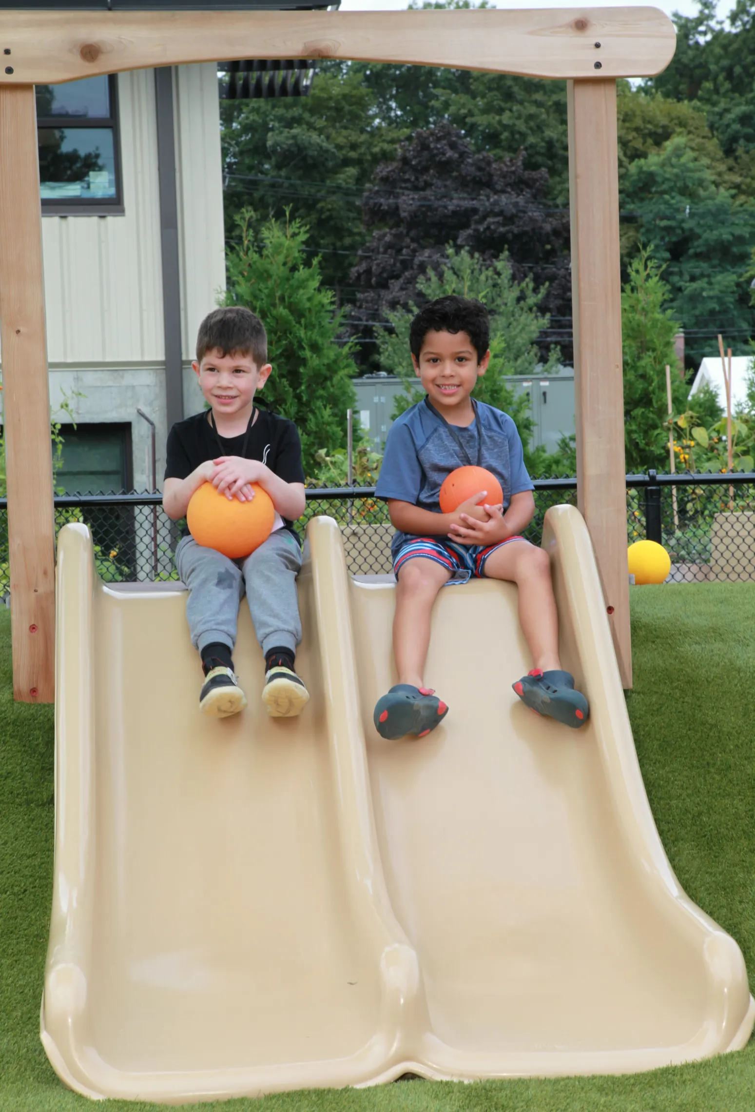 image of two young boys sitting on slides