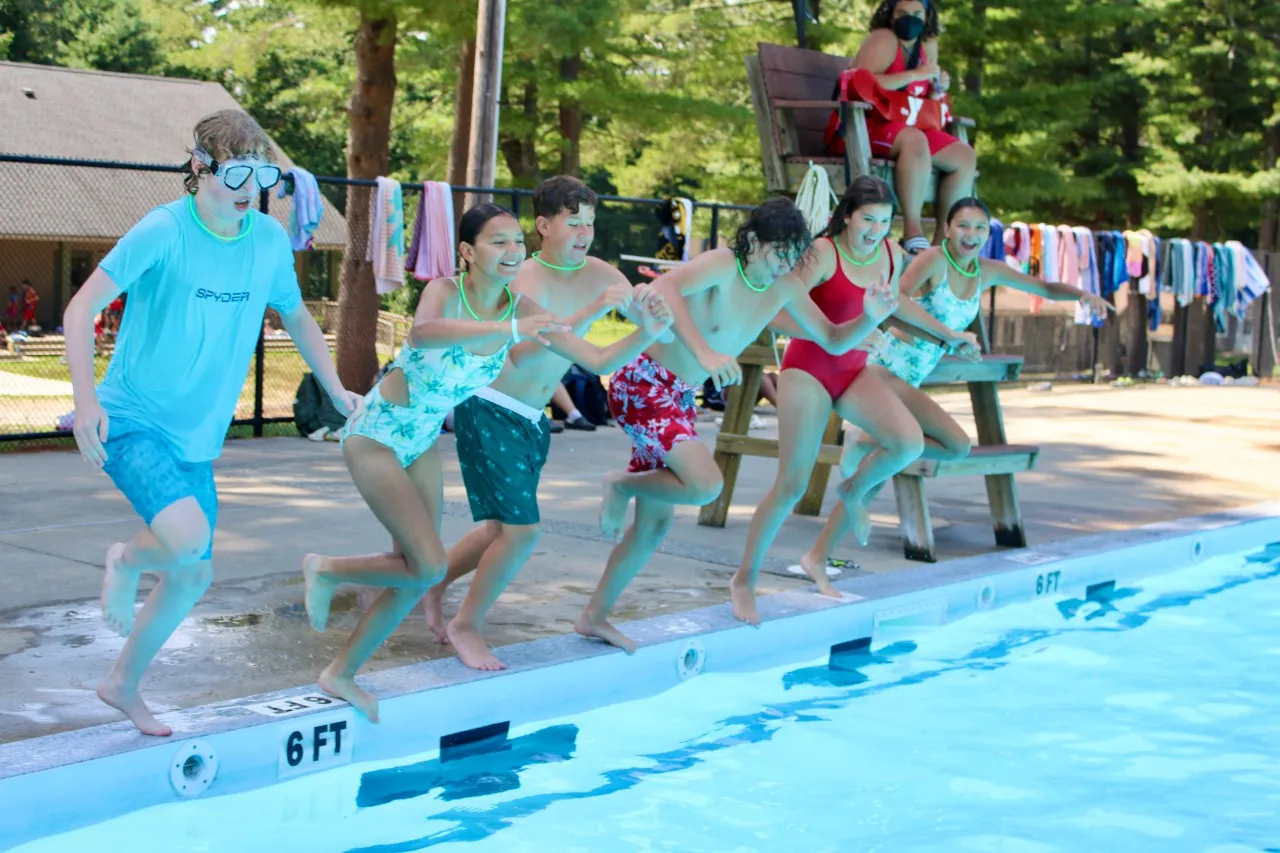 image of group of campers jumping into the pool