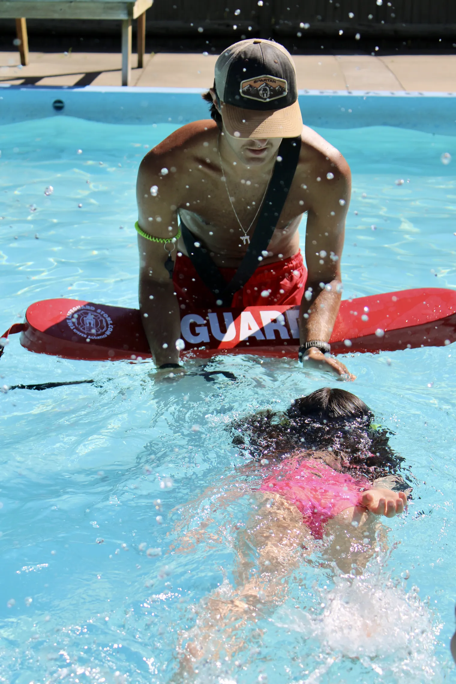 Lifeguard and swim instructor helping campers improve swim skills