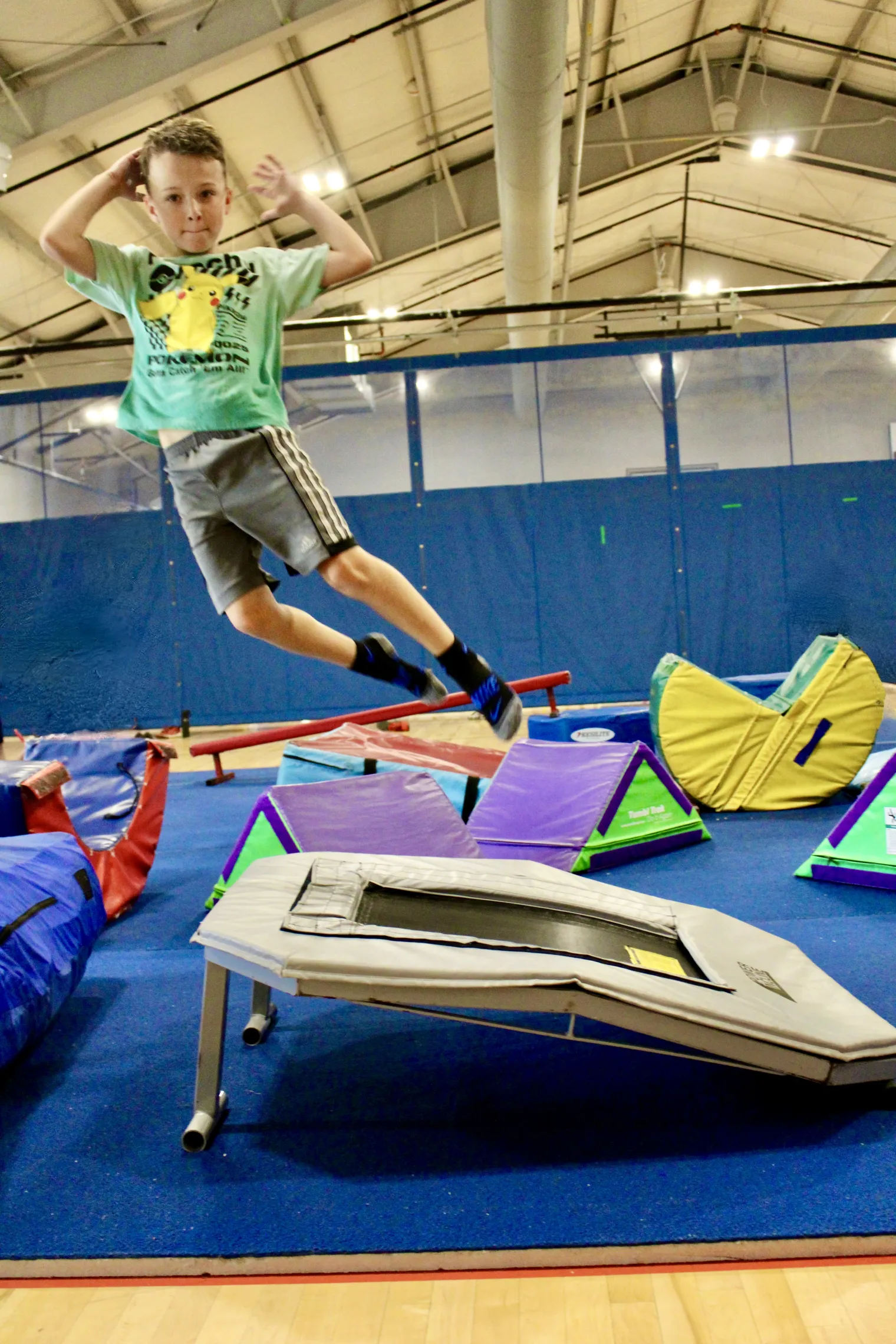 image of boy jumping in the air on obstacle course