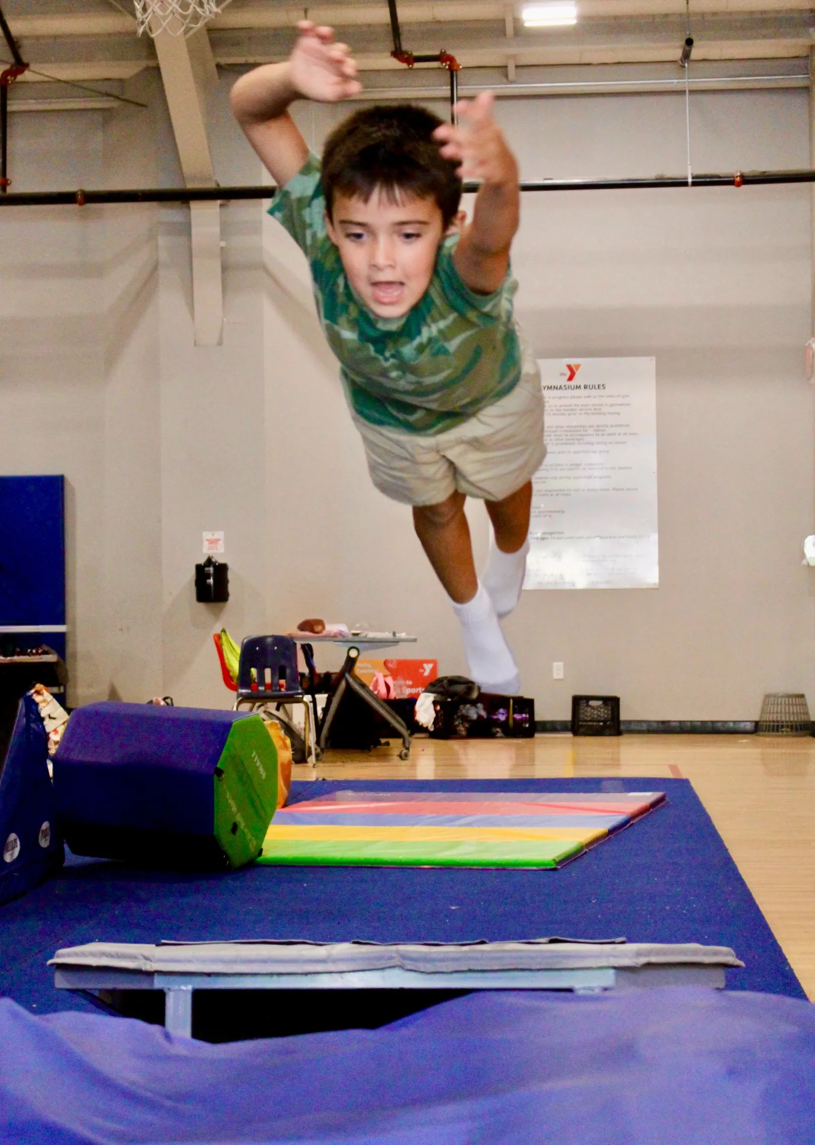 image of boy jumping in the air on an obstacle course