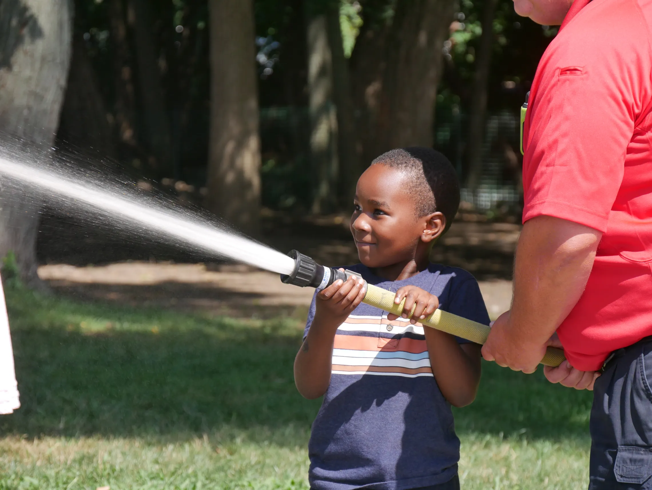 image of young boy holding a fire hose