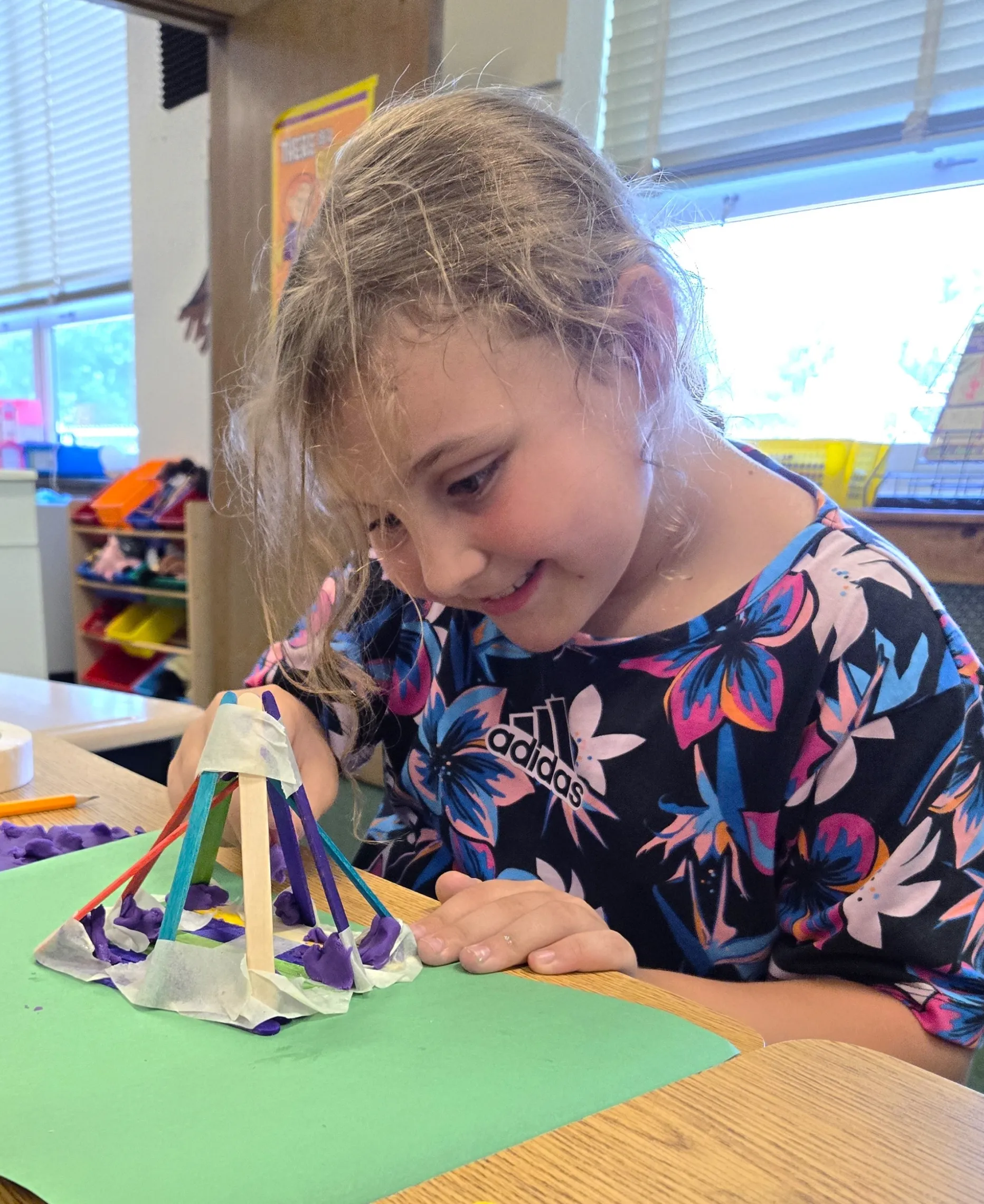 photo of young girl making a popsicle stick craft