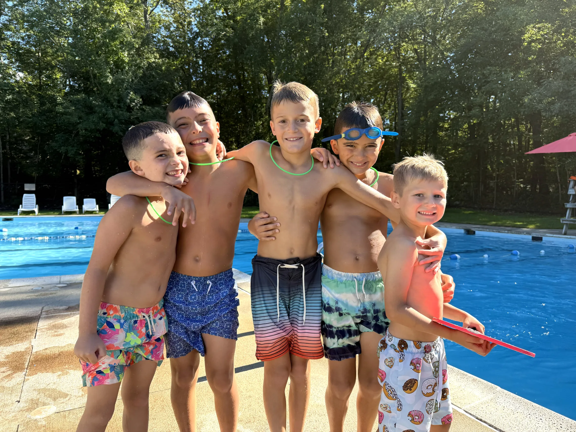 group of young male campers posing next to the pool