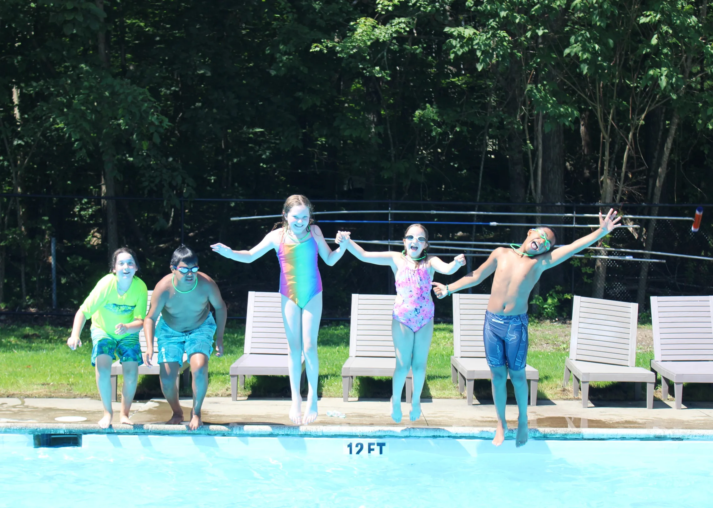 campers jumping into the pool