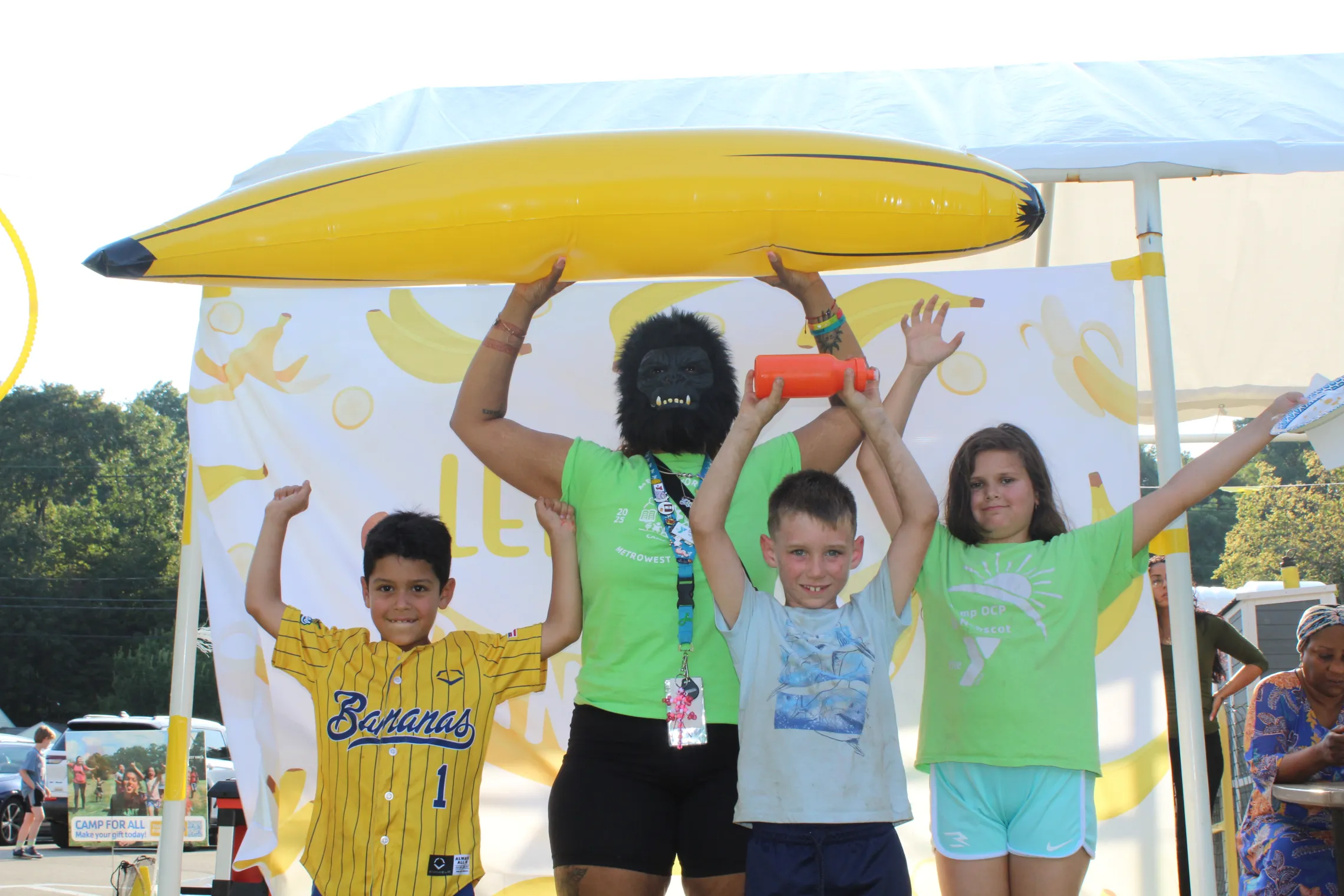 campers and counselor holding up an inflatable banana