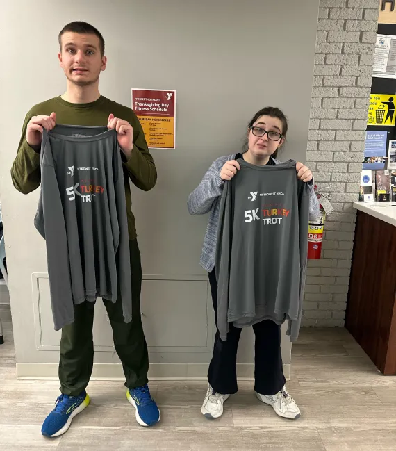 image of two 5k treadmill turkey trot participants holding gray shirts