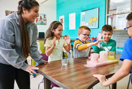 teacher doing a science project with kids at our after school program