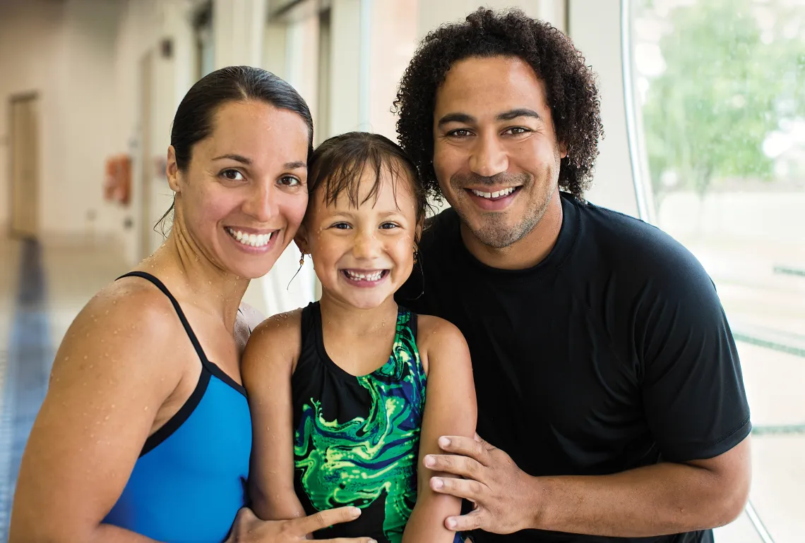 mom and dad with daughter at pool