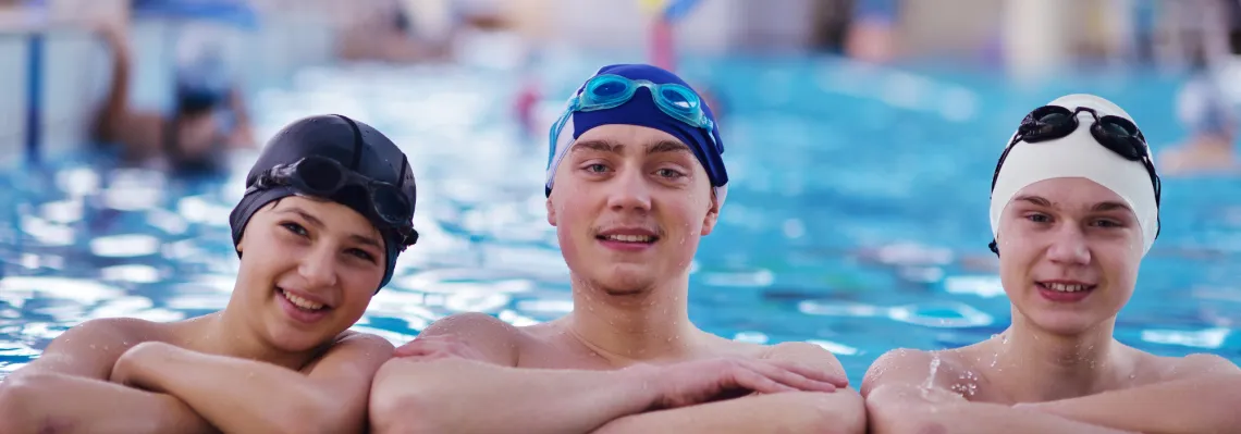 three teens at the edge of the pool