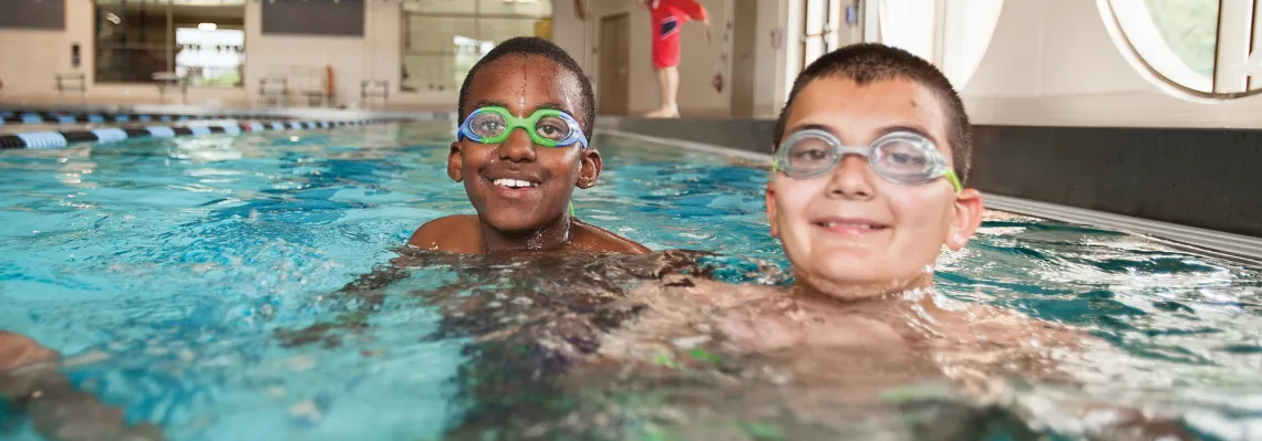 two boys in the pool wearing goggles