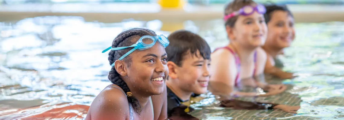 youth swimmers lined up at the edge of the pool