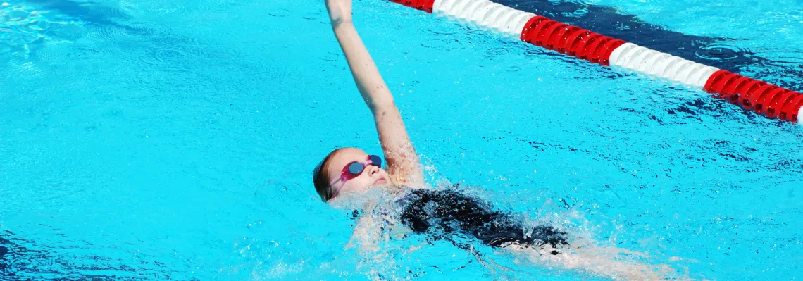 close up of young girl doing the backstroke in the pool