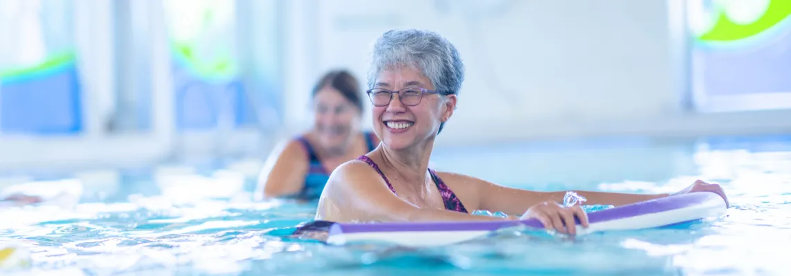 older woman smiling in the pool 