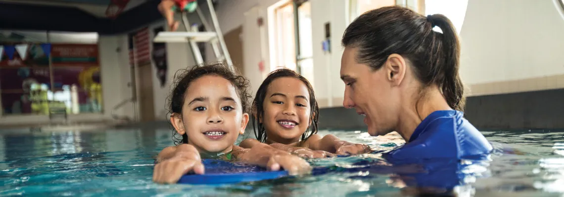 two young girls learning to swim