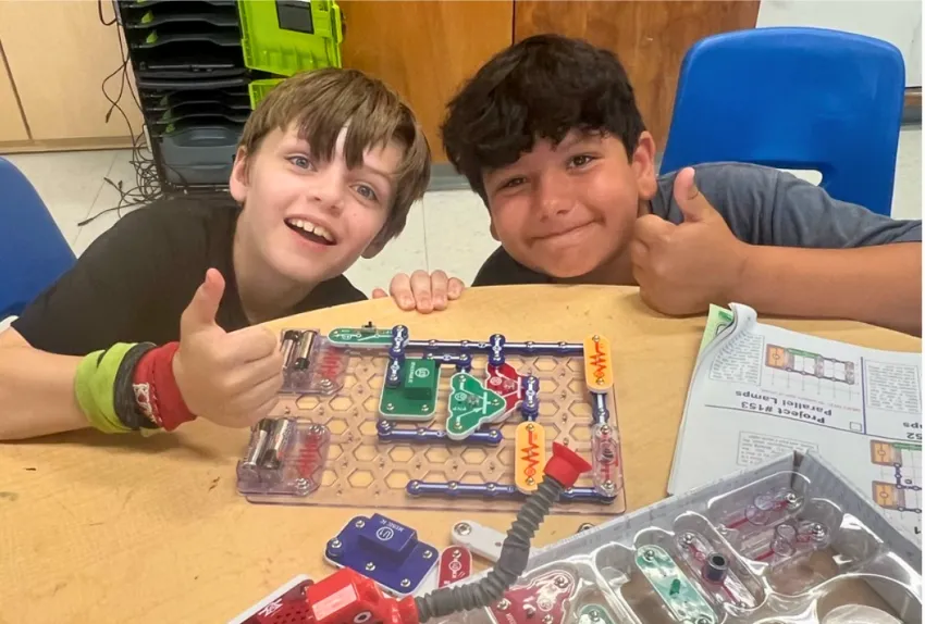 two boys showing off their project