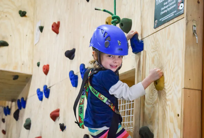 young girl on indoor rock climbing wall