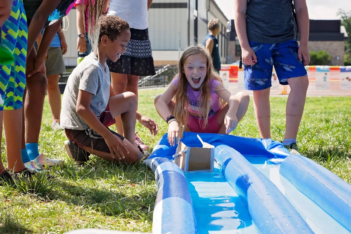 boy and girl playing with handmade boat