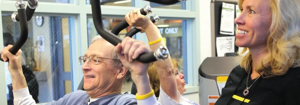 fitness instructor helping adult male with exercises