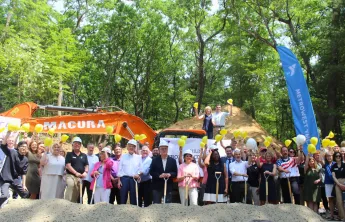 A large group of elected officials and metrowest residents pose at the construction site.
