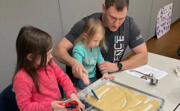 young girls and their dad together at cooking class