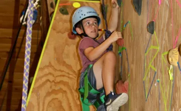 photo of boy on indoor climbing wall